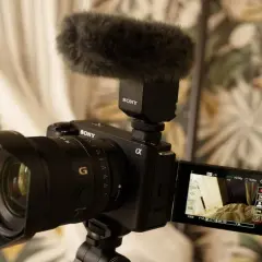 Kamera Sony z mikrofonem na statywie, gotowa do nagrywania. Idealny sprzęt do tworzenia treści, np. vlogów.